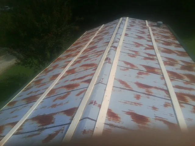 Rusted metal roof panels with new wood purlins before replacement — Storm Damage Roof Repair in Ashby by Roofing Brothers